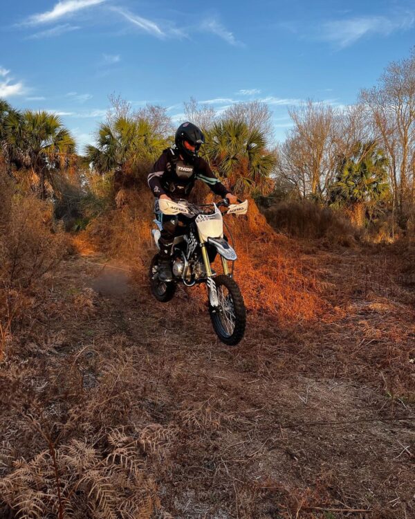 Rider standing beside the SYX Moto 125cc Dirt Bike