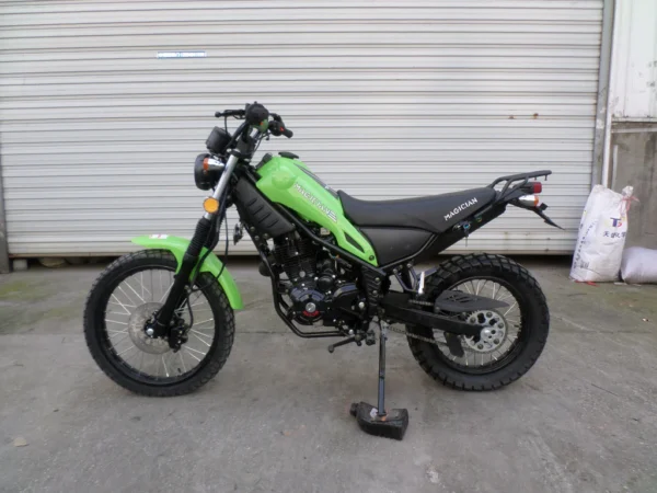 A green motorcycle parked in front of a garage.