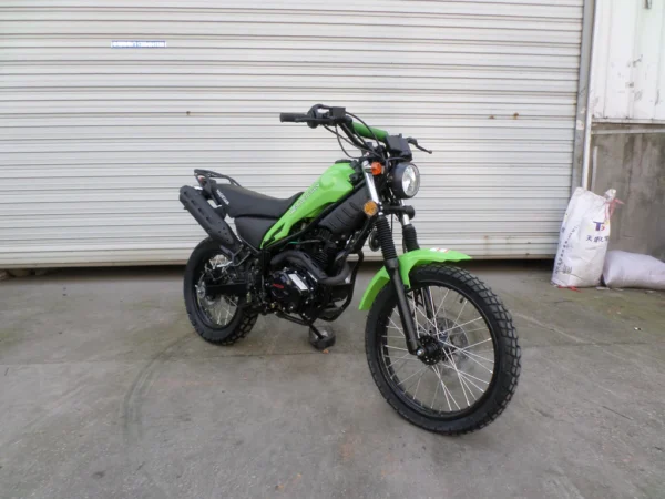 A green motorcycle parked in front of a garage.