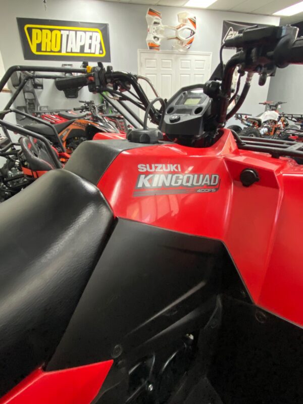 A red and black quad bike parked in a room.