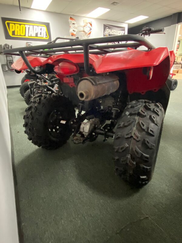 A red four wheeler parked in the middle of a room.