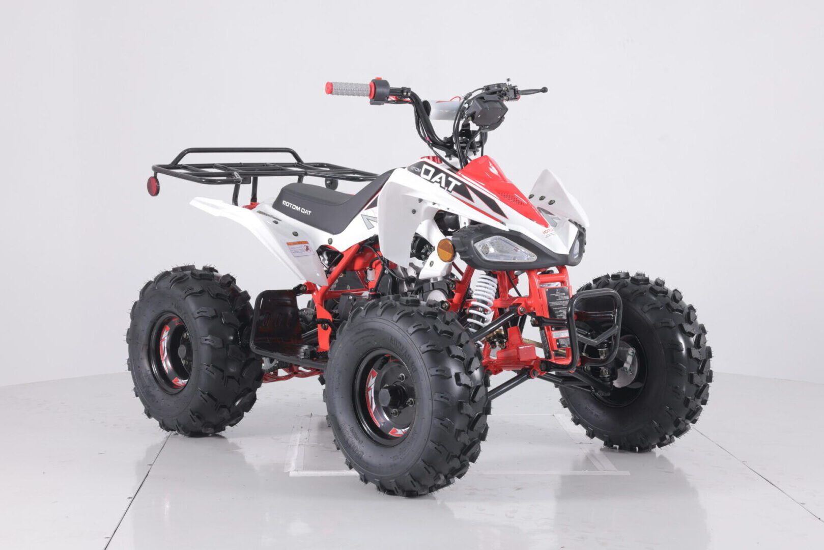 A red and white atv is parked on the ground