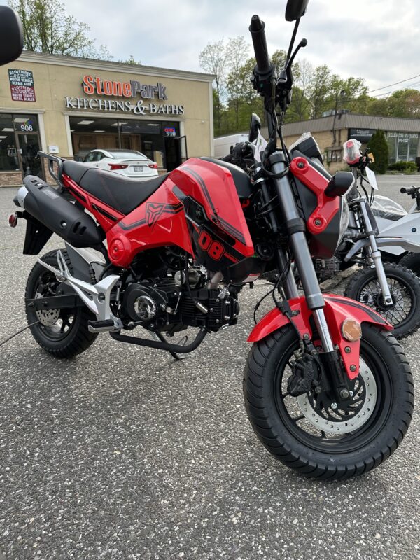 A red motorcycle parked in front of a building.