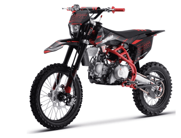 A red and black dirt bike is parked on the ground.