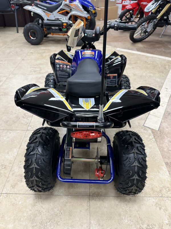 A blue and black four wheeler is parked on the floor.