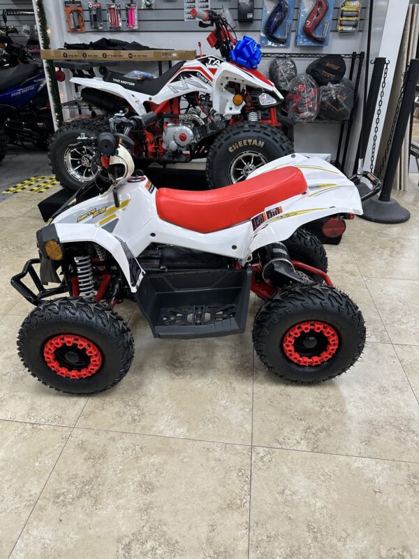 A white and red atv is parked in the showroom.