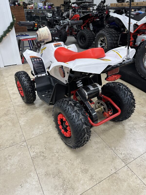 A white and red four wheeler is parked in a showroom.