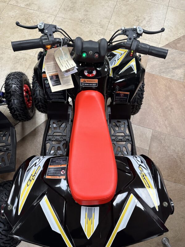 A red and black four wheeler with a tag on the seat.