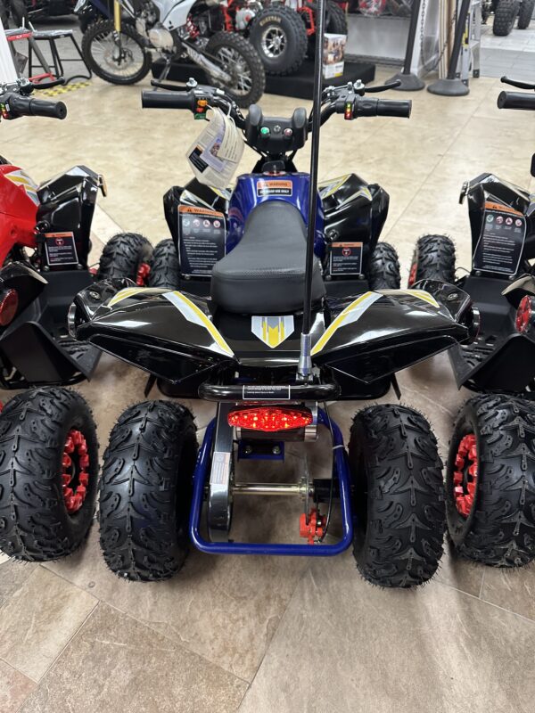 A group of four different colored atvs parked on the floor.