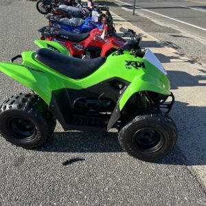 A group of four kids on atv 's parked in the street.