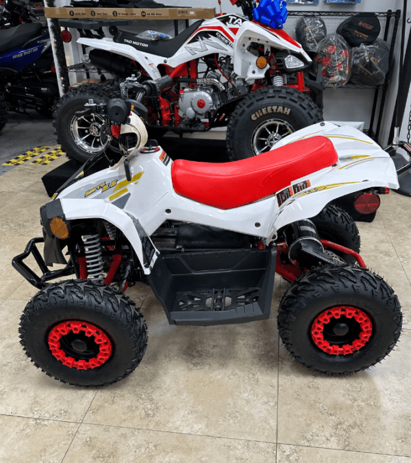 A red and white atv parked in a showroom.