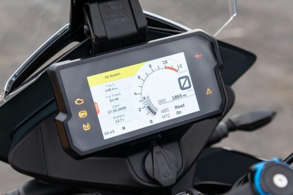 A motorcycle dashboard with an electronic device on it.